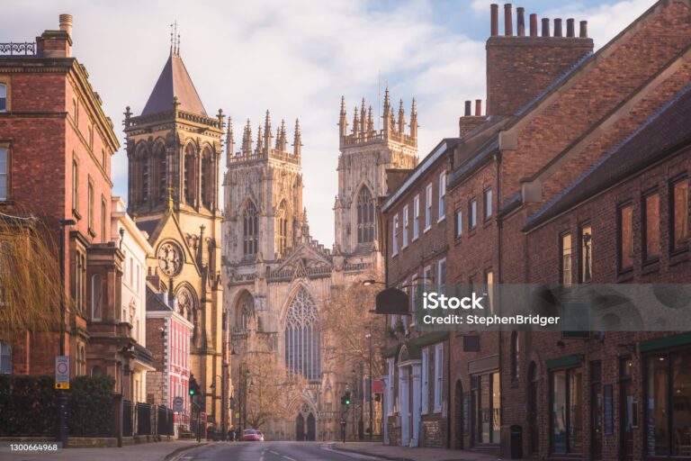Morning golden light on the historic old town of York along Museum St. looking towards York Minster Cathedral.